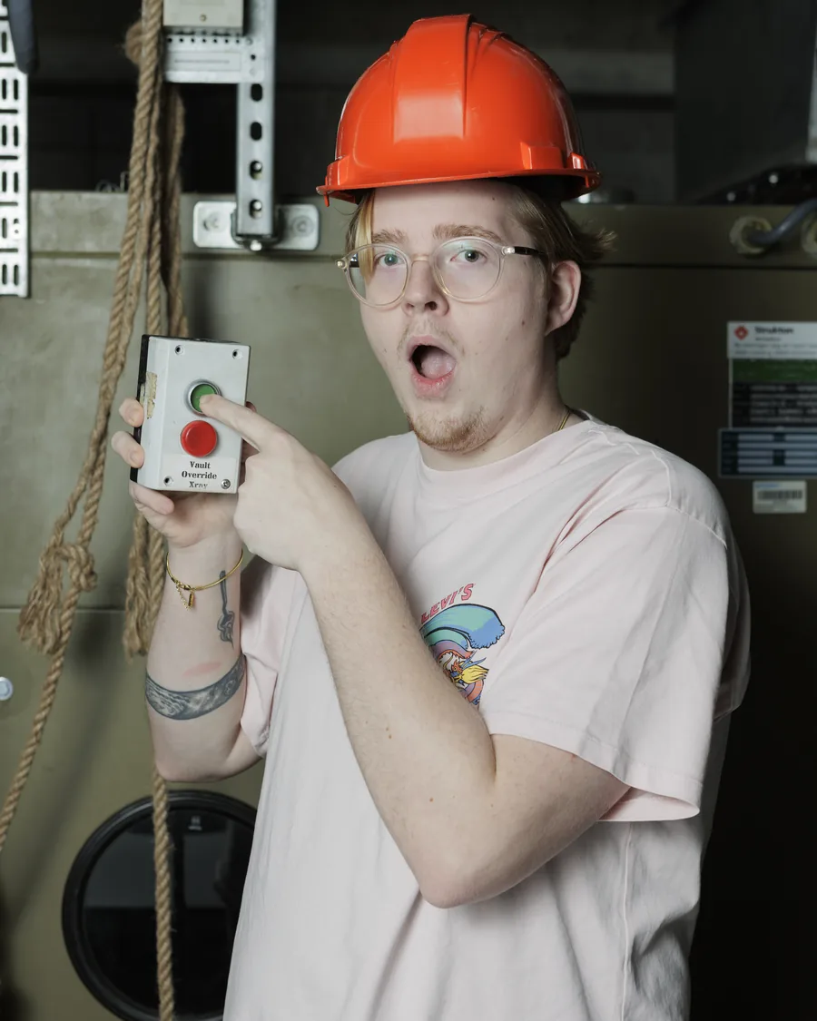 Jeremy Lubbersen met een oranje bouwhelm en een grote rode knop