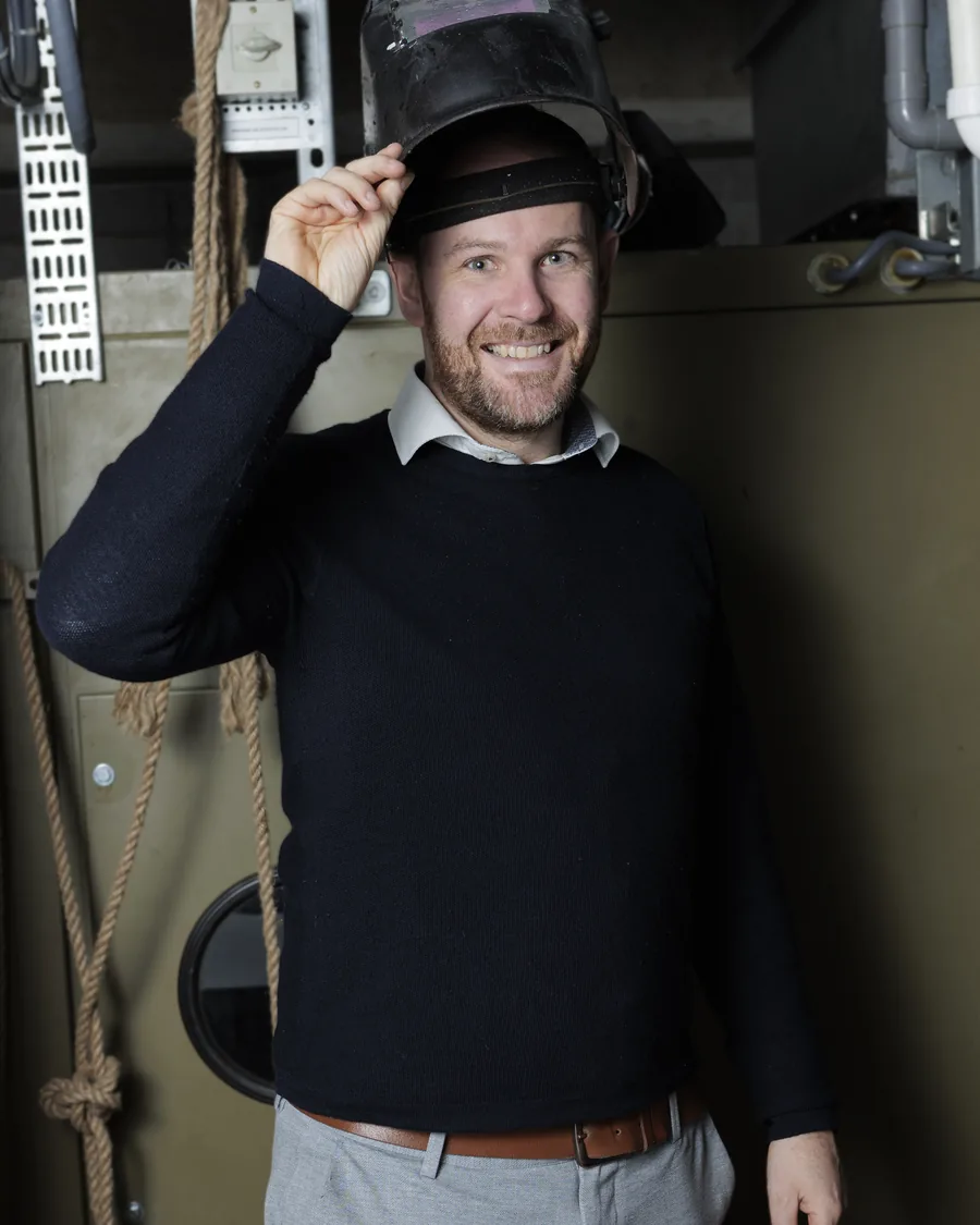 Johan Post met een lashelm op zijn hoofd in de werkplaats